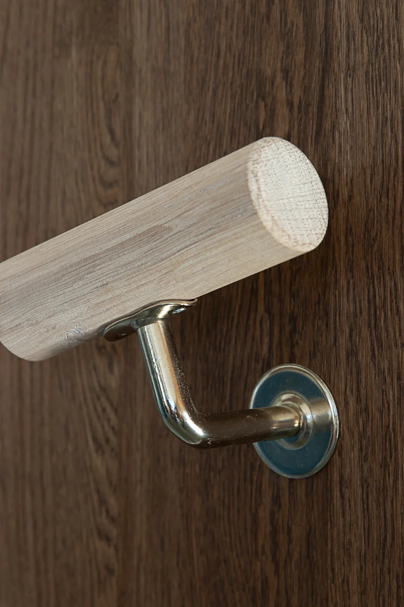 Light ash wooden handrail with stainless steel wall bracket