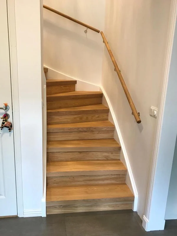 Installed wooden handrail on an oak staircase in a bright Scandinavian home
